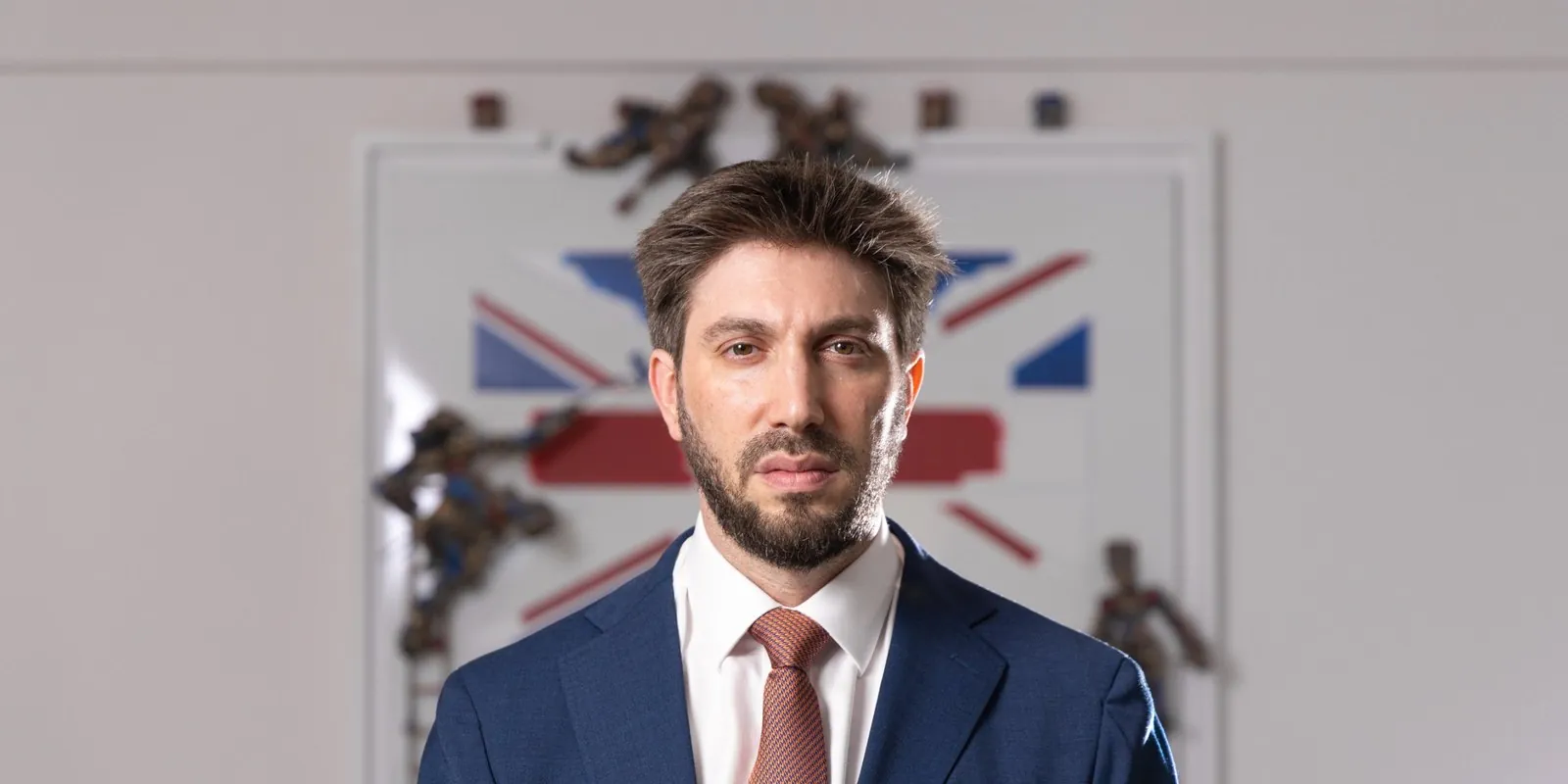 Daniel Seal in a navy suit in front of a Union Jack artwork