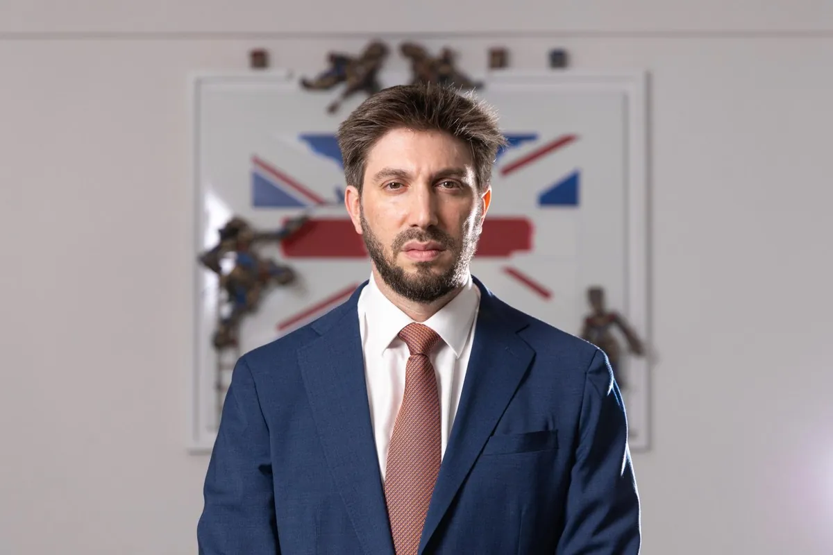 Daniel Seal in a navy suit in front of a Union Jack artwork
